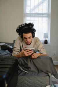 Teen with headphones on focusing on tablet